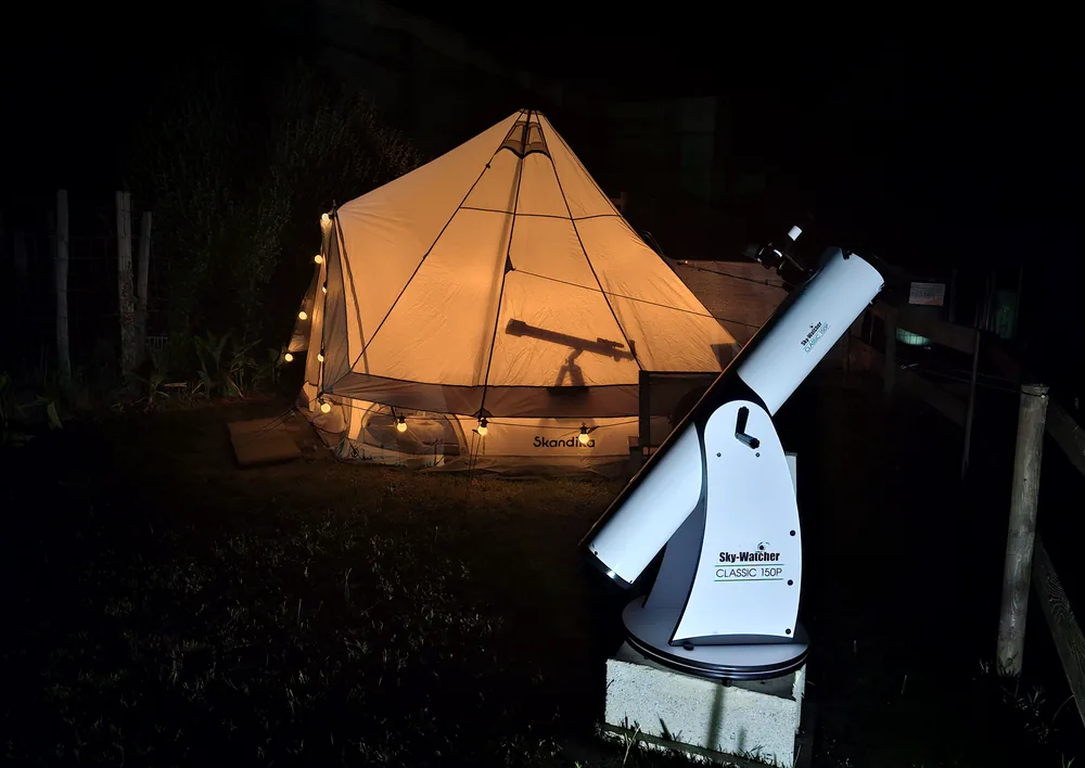 L'Astro-Tipi illuminé et son télescope sous le ciel étoilé