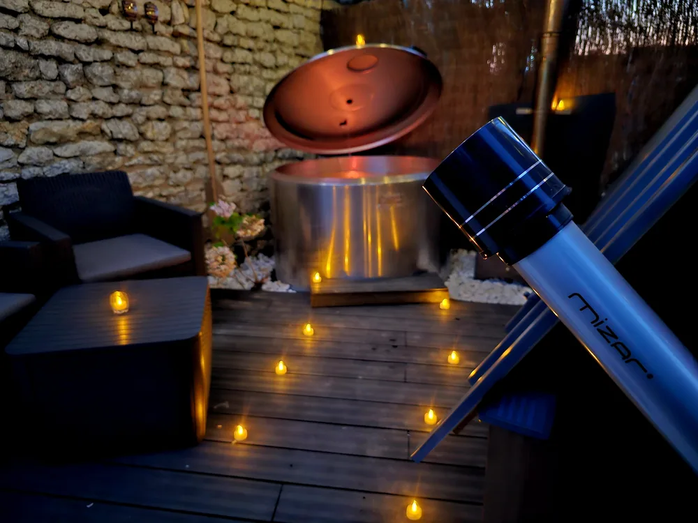 Le bain nordique entouré de bougies, télescope au premier plan